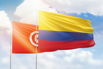 Sunny blue sky and flags of colombia and tunisia