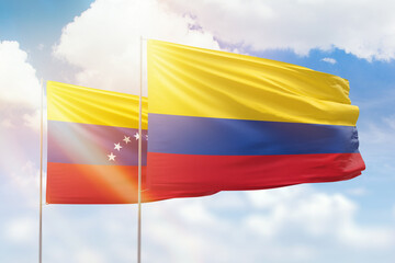Sunny blue sky and flags of colombia and venezuela