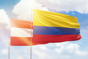 Sunny blue sky and flags of colombia and austria