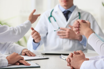 Doctors sitting at table during meeting in clinic