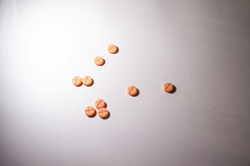 small orange pills on a white background, anti-nausea pills
