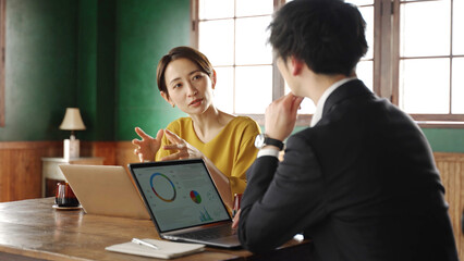 事務所でデスクワークをする人々