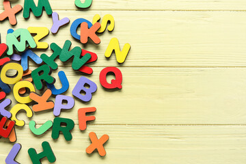 Colorful letters on yellow wooden background. Alphabet concept