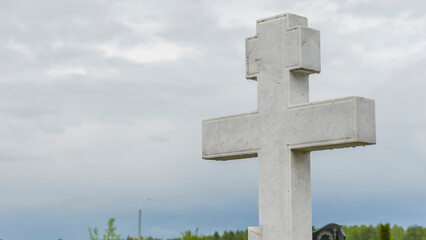 White tombstone stone cross in the city cemetery. City geaveyard.