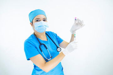 Beautiful woman doctor wearing mask face, uniform and blue surgical cap, stethoscope and latex gloves, preparing injection on white background