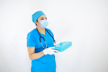 beautiful woman medical wearing face mask, uniform and blue surgical cap, stethoscope and latex gloves, preparing instruments case on white background
