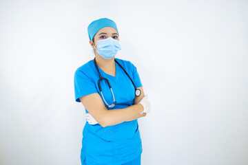 
Beautiful female doctor wearing uniform and blue surgical cap, face mask and latex gloves. professional woman on white background