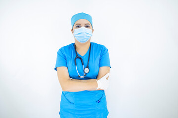 
Beautiful female doctor wearing uniform and blue surgical cap, face mask and latex gloves. professional woman on white background