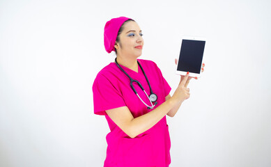 beautiful woman medical assistant, wearing pink uniform and pink surgical cap, stethoscope, using the tablet to display results on white background