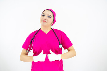Beautiful female medical assistant wearing uniform and pink surgical cap, stethoscope, putting latex gloves, on white background