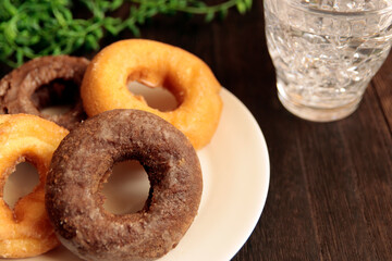 Donuts with high calories and plenty of sugar in the plate on the table