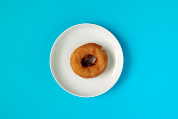 Donuts with high calories and plenty of sugar in the plate on the table