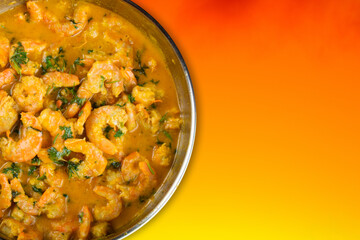 Delicious shrimp moqueca with a vivid orange background