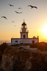 Seashore lighthouse, beacon during sunset.