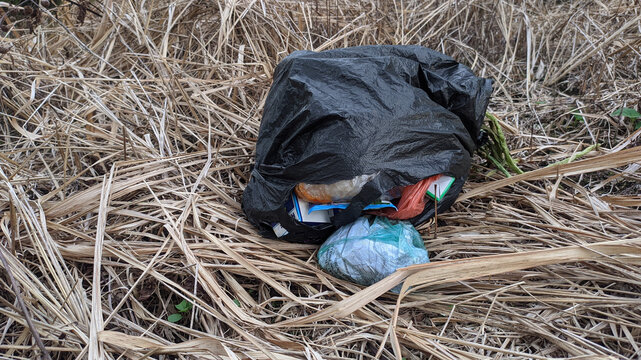 A black bag with a plastic bottle on the ground. This asset is suitable for environmental campaigns, waste management awareness, and sustainable lifestyle concepts in graphic design and advertising.