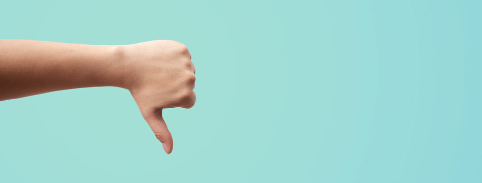 a man's hand with thumb down giving dislike
