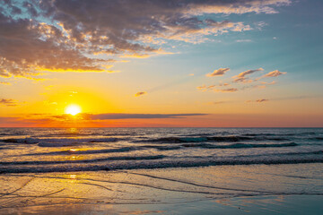Beautiful sunrise with the sun peaking out over the ocean