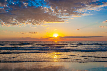 Fototapeta na wymiar Beautiful sunrise with the sun peaking out over the ocean