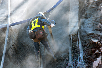 Japanese slope protection work "free frame method", spraying mortar on the reinforcing bars covered in a mesh pattern on the slope: civil engineering work