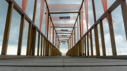 Obraz premium a beach pier, for visitors' refreshing activities, taking pictures of men, while observing the beach