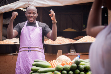 An African Nigerian male trader, seller, business man or shop owner, having an apron on his body,...