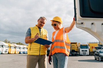 Mature woman and man at cargo warehouse, truck drivers delivery inspection  © troyanphoto