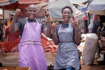 Male and female African Nigerian traders, sellers, business persons or entrepreneurs with aprons,...