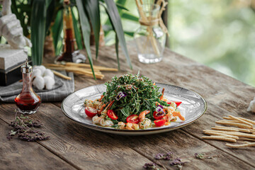 Portion of gourmet shrimp and arugula salad on wooden background