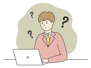 パソコンの前で悩んでいるスーツを着た男性