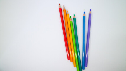 colored pencils in row on a white background top view.