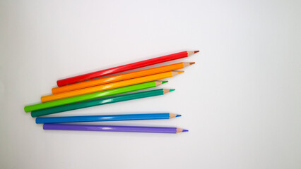 colored pencils in row on a white background top view.