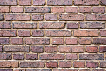 Wall is made of old durable red brick. Textured background. Copy space. 