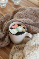 Obraz na płótnie Canvas Cup of hot chocolate with figure cute marshmallows on wooden background, warm knitted plaid, cozy homely weekend, concept of seasonal winter autumn fall leasure, beverage drink