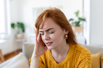 Naklejka premium Closeup view frown face of woman feeling strong headache touch temple to reduce severe pain, suffering from panic attack in office, migraine overworked person or hangover alcohol abuse concept