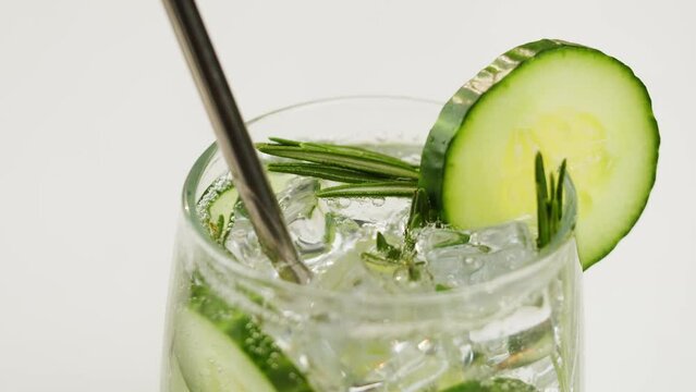 Cucumber and rosemary lemonade. Gin tonic cocktail close-up, healthy drink on white background. Detox drinking, summer refreshment concept.
