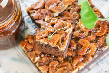 Close up stack of golden brown square slice toffee cake combination chocolate and coffee cake topping cashew nut and caramel sauce or syrup look so delicious and sweet. Homemade bakery concept.