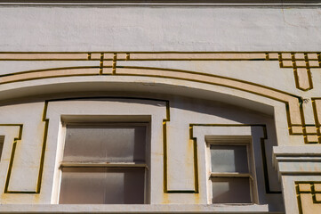 Faded and Decaying Arched Facade and Windows on an Art Deco Style Building.