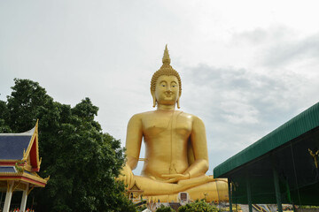 Golden big Buddha statue at Wat Muang located in Ang Thong province, Thailand. People come to pray respect to the large golden Buddha statue.