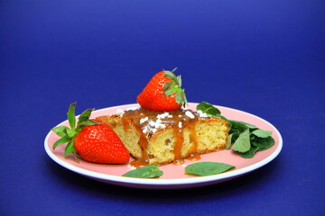 brownies with strawberries. on the plate. bay leaf, souvenir figurine of a girl. Confectionery, cakes. food. sweet concept.	