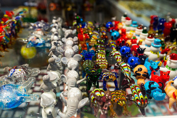 Variety of Murano glass products on shelves of souvenir shop in Venice..