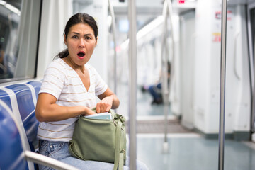 Oriental woman feeling shocked when she's discovered theft from her shoulder bag in metropolitan...