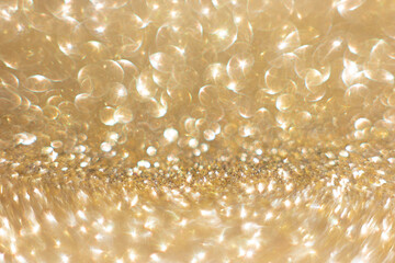 Defocused abstract colorful twinkle light background. Gold glittery bright shimmering background use as a design backdrop.