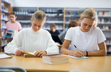 Two friends are studying in the school library. Exam preparation