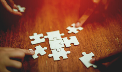 teamwork unity and cooperation concept hand holding jigsaw close-up piece of hand that connect...