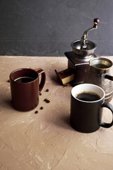 coffee grinder two mugs of cinnamon coffee beans and a turk for brewing coffee on the table