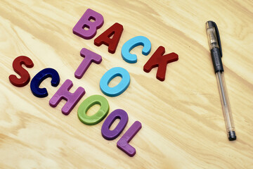 the phrase back to school laid out of multicolored letters on the table and a fountain pen next to the concept of education school