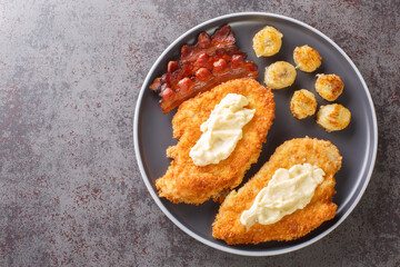 Maryland Fried Chicken With White Gravy served with bananas and bacon close-up in a plate on the table. Horizontal top view from above