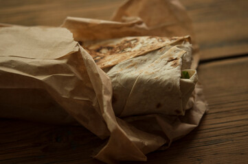 Shawarma wrap sandwich on white wood table arabic food sauce