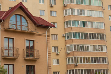 Obraz premium apartment building with colorful facades. Modern minimalistic architecture with lots of square glass Windows and flowers on the building.