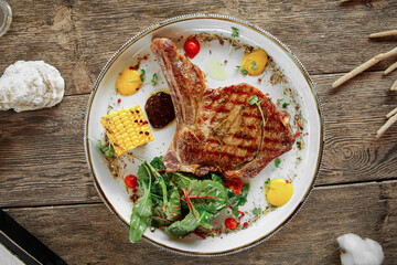 Portion of gourmet grilled beef steak on wooden background